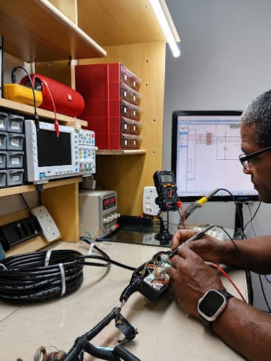 Técnico analisando um módulo com o esquemático do circuito aberto no monitor